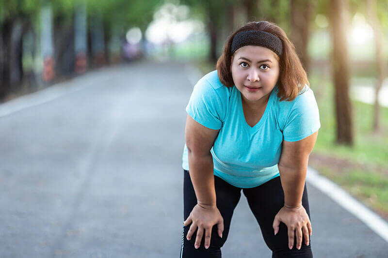 Woman in Blue Top Rests During Run