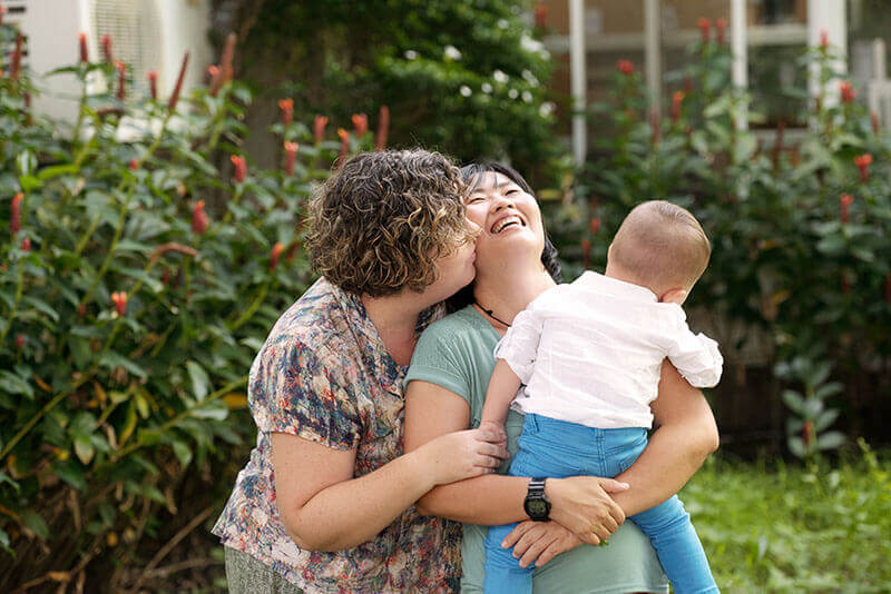 Lesbian Couple Smiling Happily with Baby