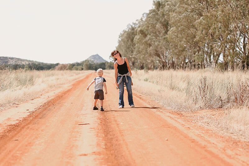 Woman and Child Standing on Country Road