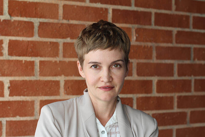 Woman with Short Hair against a Brick Wall